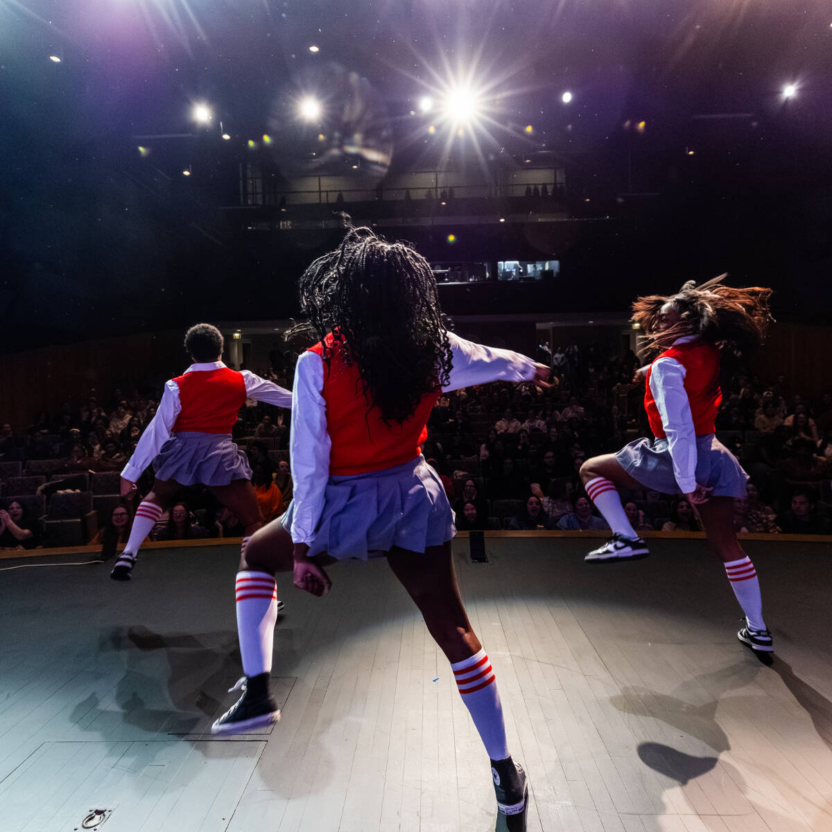 Three students dancing onstage